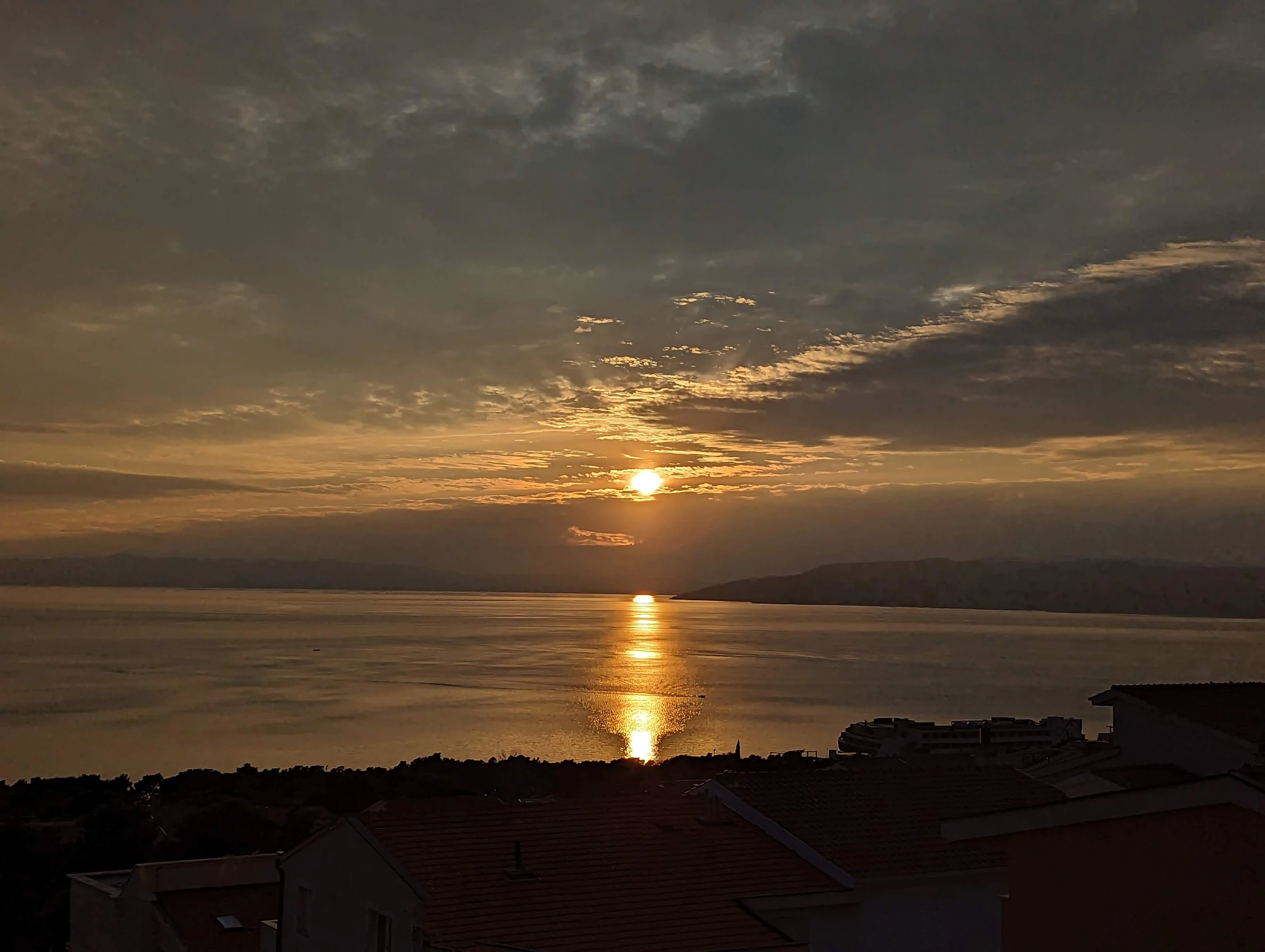 Golden sunset reflected across the Adriatic above Makarska rooftops
