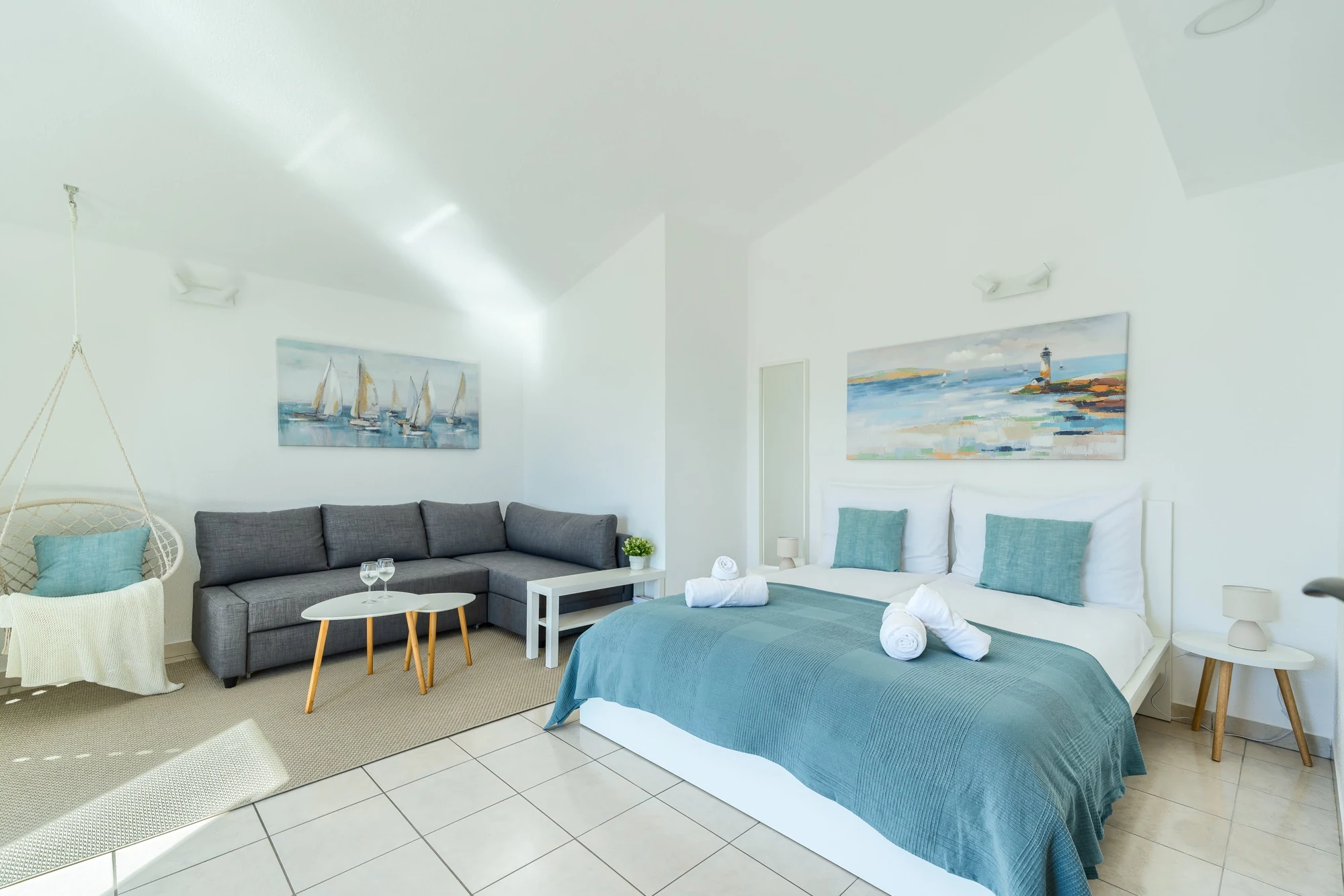 Sea View Studio Three with a double bed, grey corner sofa and hanging chair