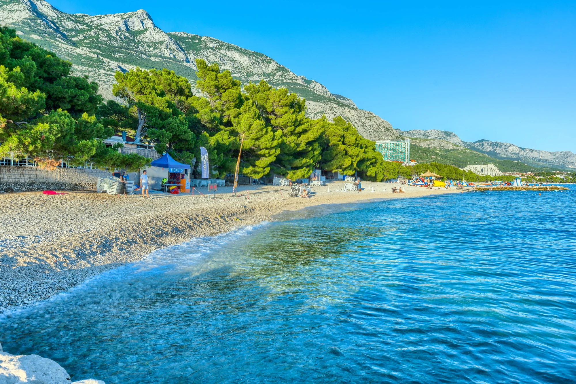Makarska’s pebbled coast and mountains beneath a blue sky